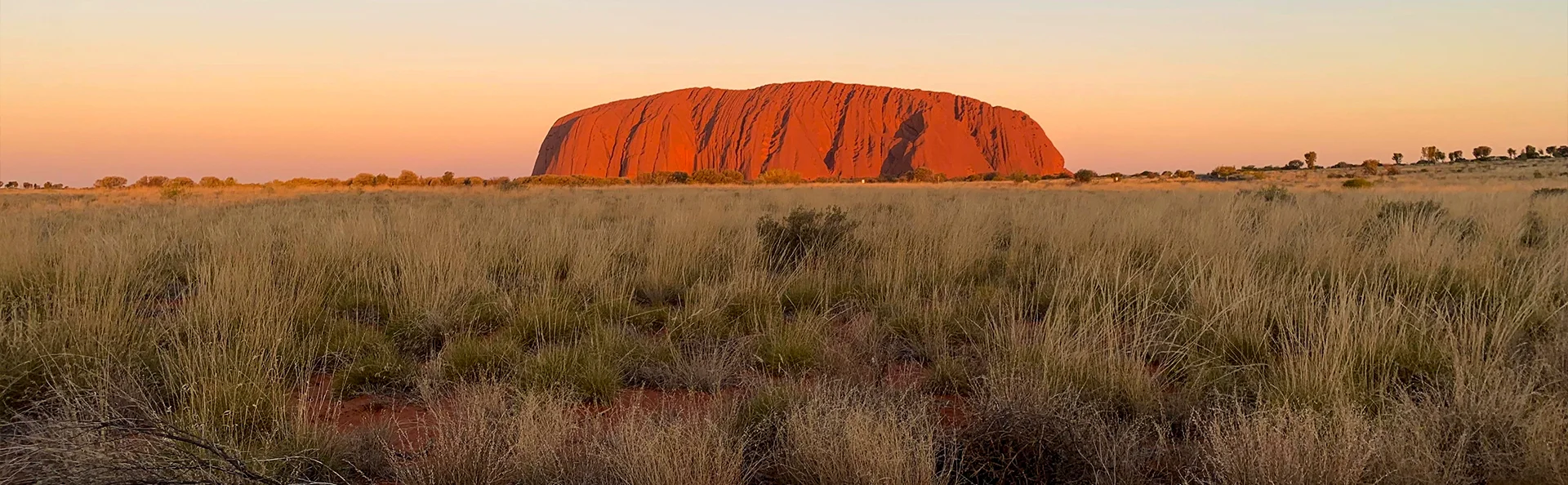 Uluru glöder rött i skymningen