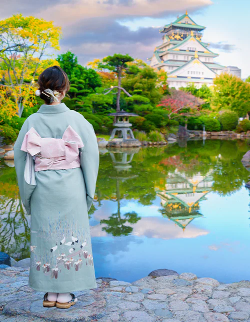 Japansk kvinna framför Osaka Castle