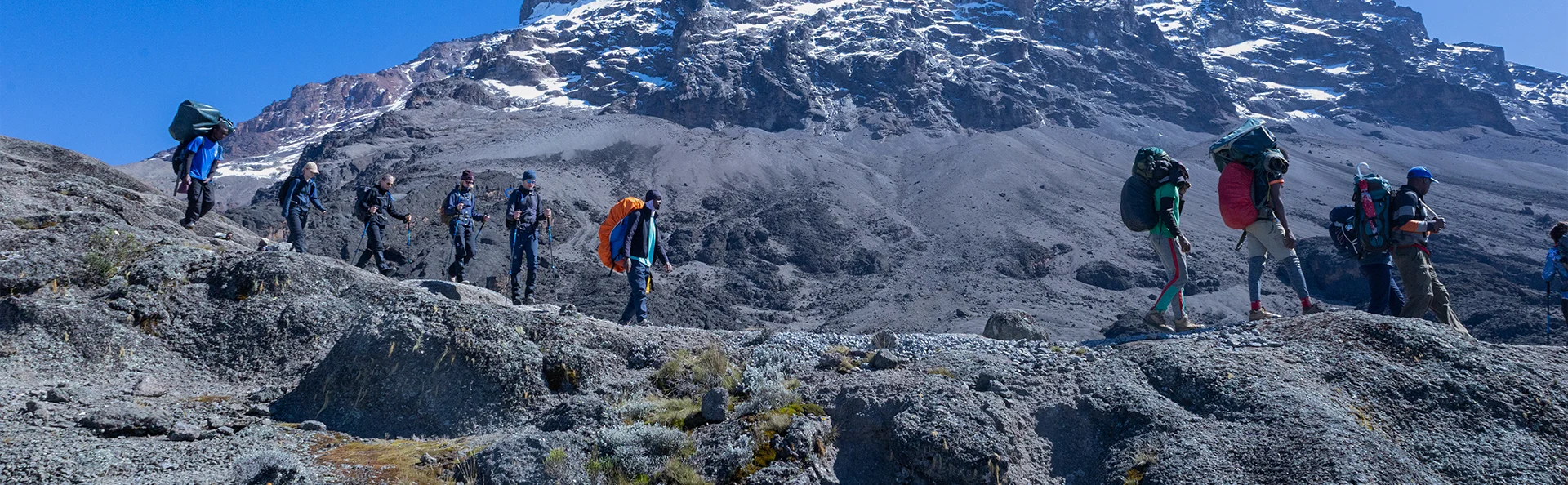 Grupp av människor vandrar uppför Kilimanjaro via Machameleden