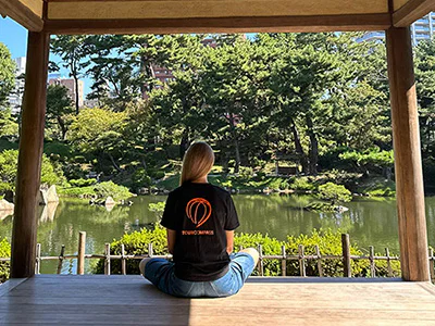 Kvinna i TourCompass-t-shirt i en vacker japansk trädgård i Hiroshima