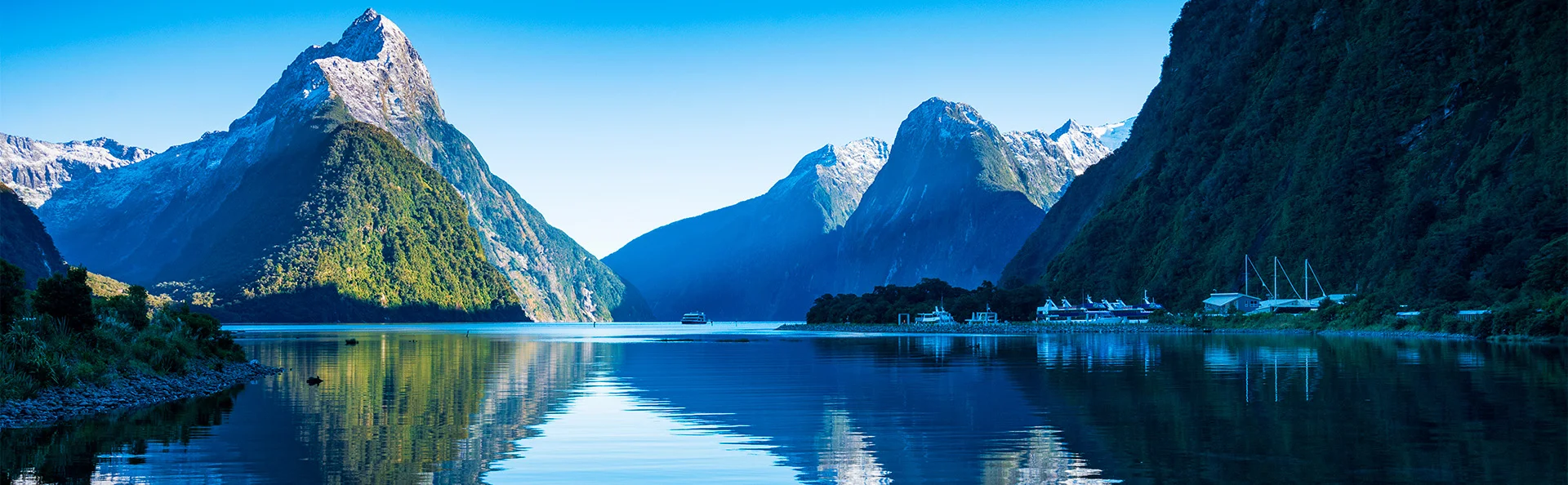 Klar, blå himmel vid Milford Sound i Nya Zeeland