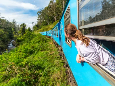 En kvinna tittar ut genom ett tågfönster i Sri Lanka