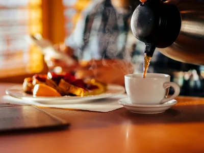 Man sitter på en diner och äter våfflor och dricker kaffe