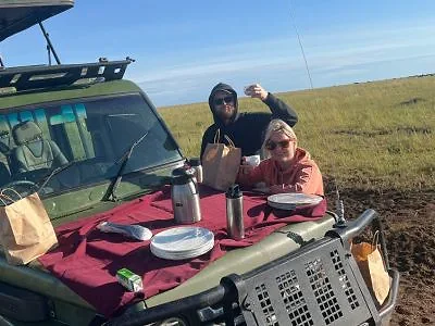 Två personer äter frukost i safaribilen