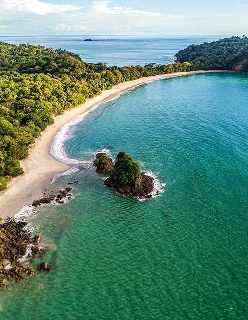 Flygfoto av den tropiska stranden Espadilla och kusten vid nationalparken Manuel Antonio