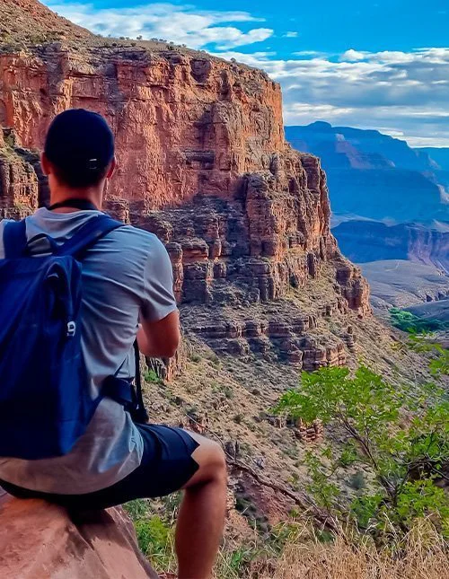 Man på en klippa längs Bright Angel-leden med utsikt över South Rim i Grand Canyon National Park